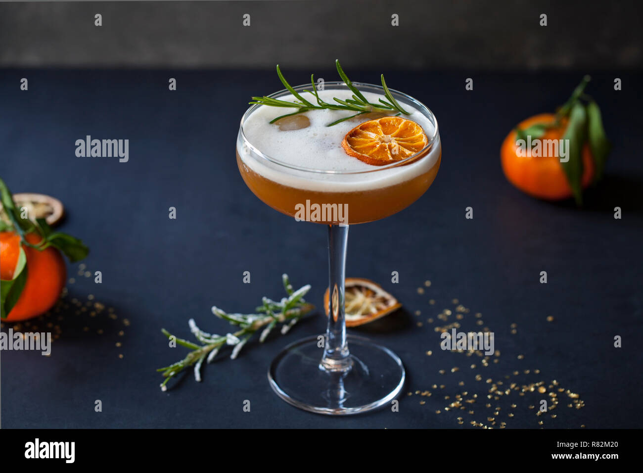 Christmas cocktail of amaretto sour with dehydrated clementine and