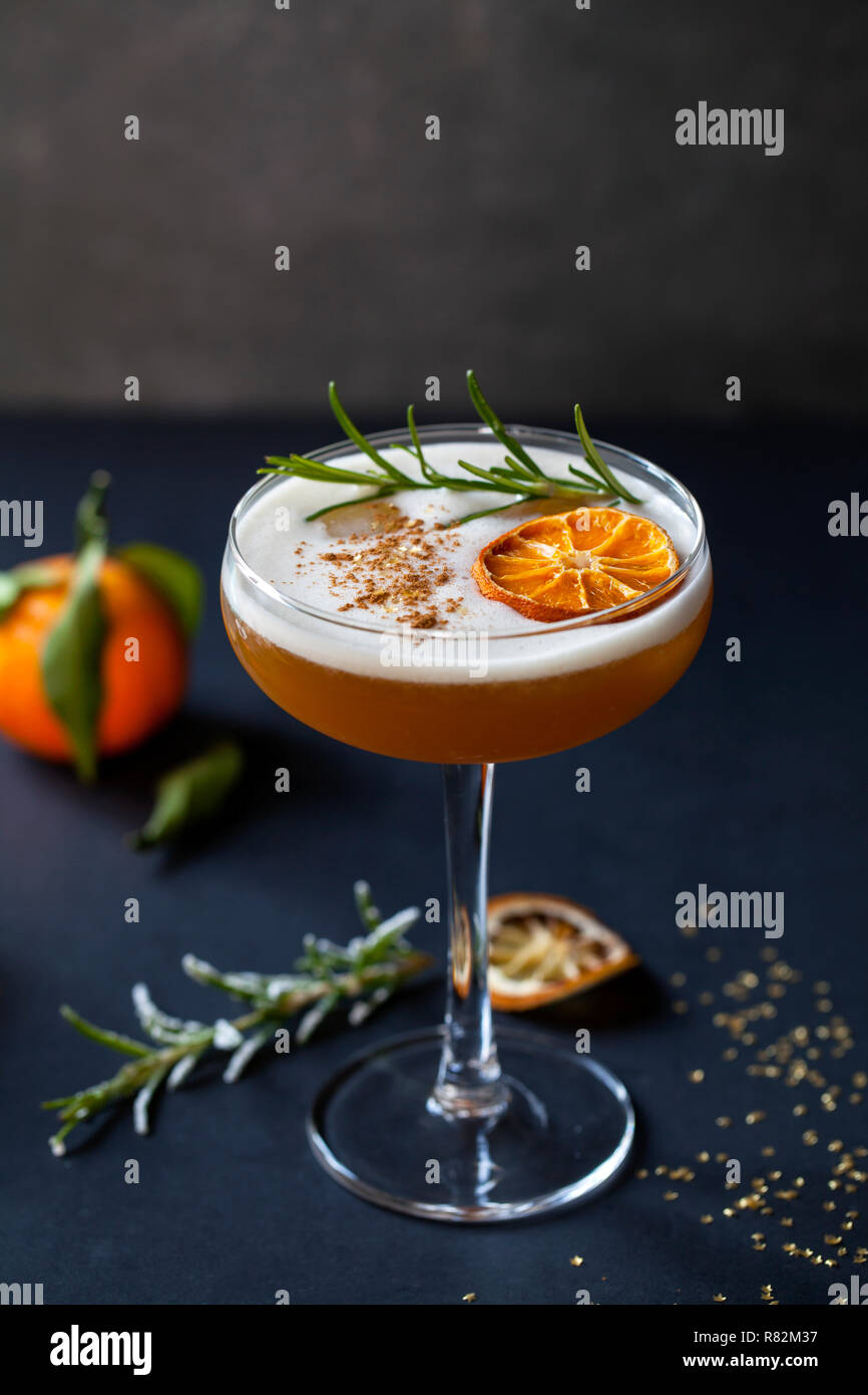 Christmas cocktail of amaretto sour with dehydrated clementine and