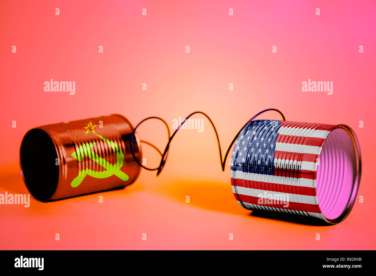 tin can phone with USA and Soviet Union Flags.communication concept on pink Stock Photo
