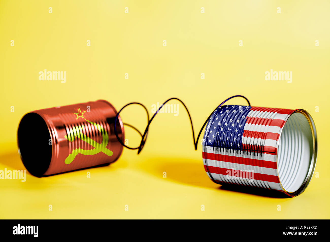 tin can phone with USA and Soviet Union Flags.communication concept on yellow Stock Photo