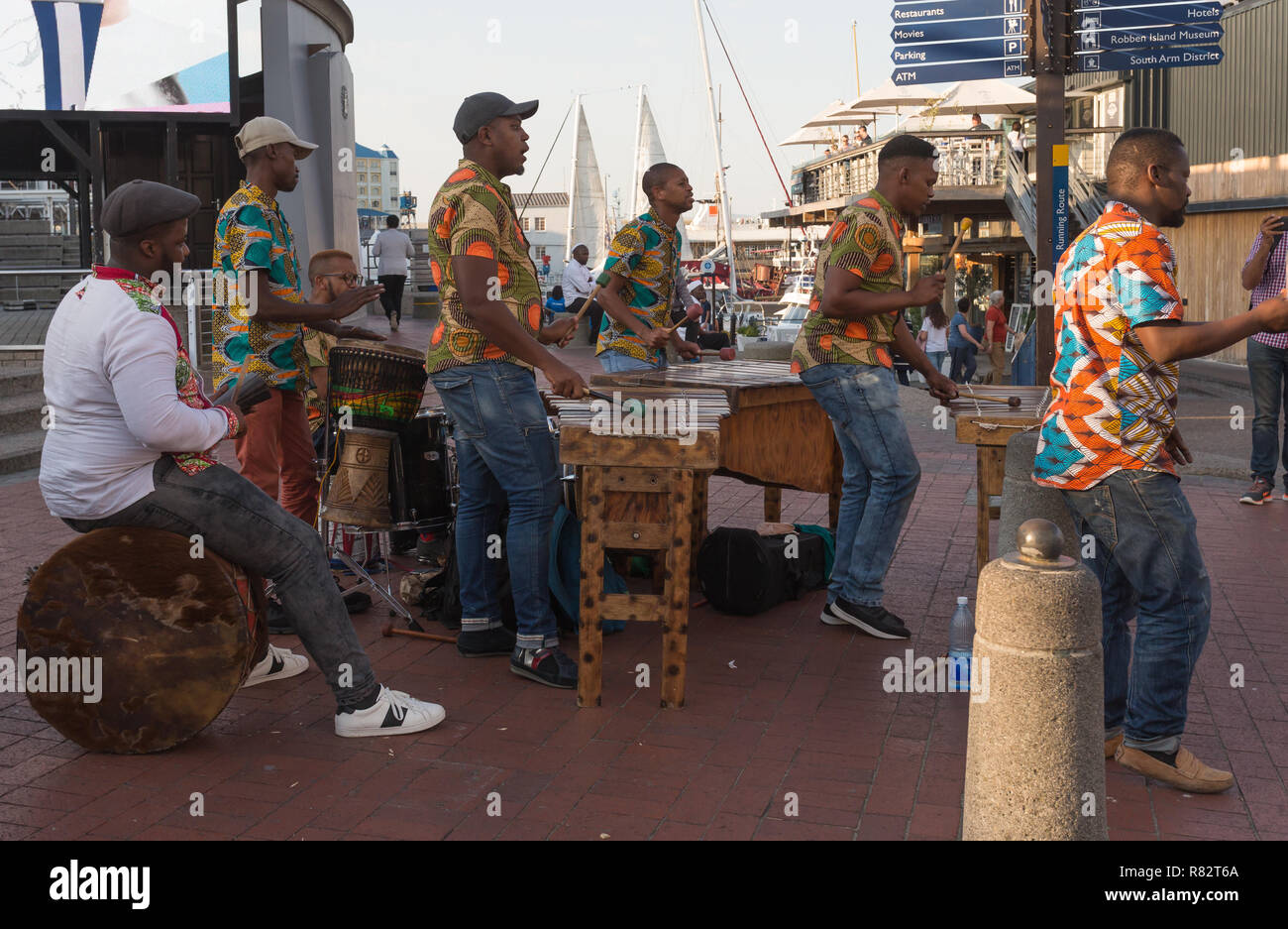 Marimba band performing as street performers and dressed in African vibrant coloured shirts at the V&A Waterfront in Cape Town, South Africa Stock Photo