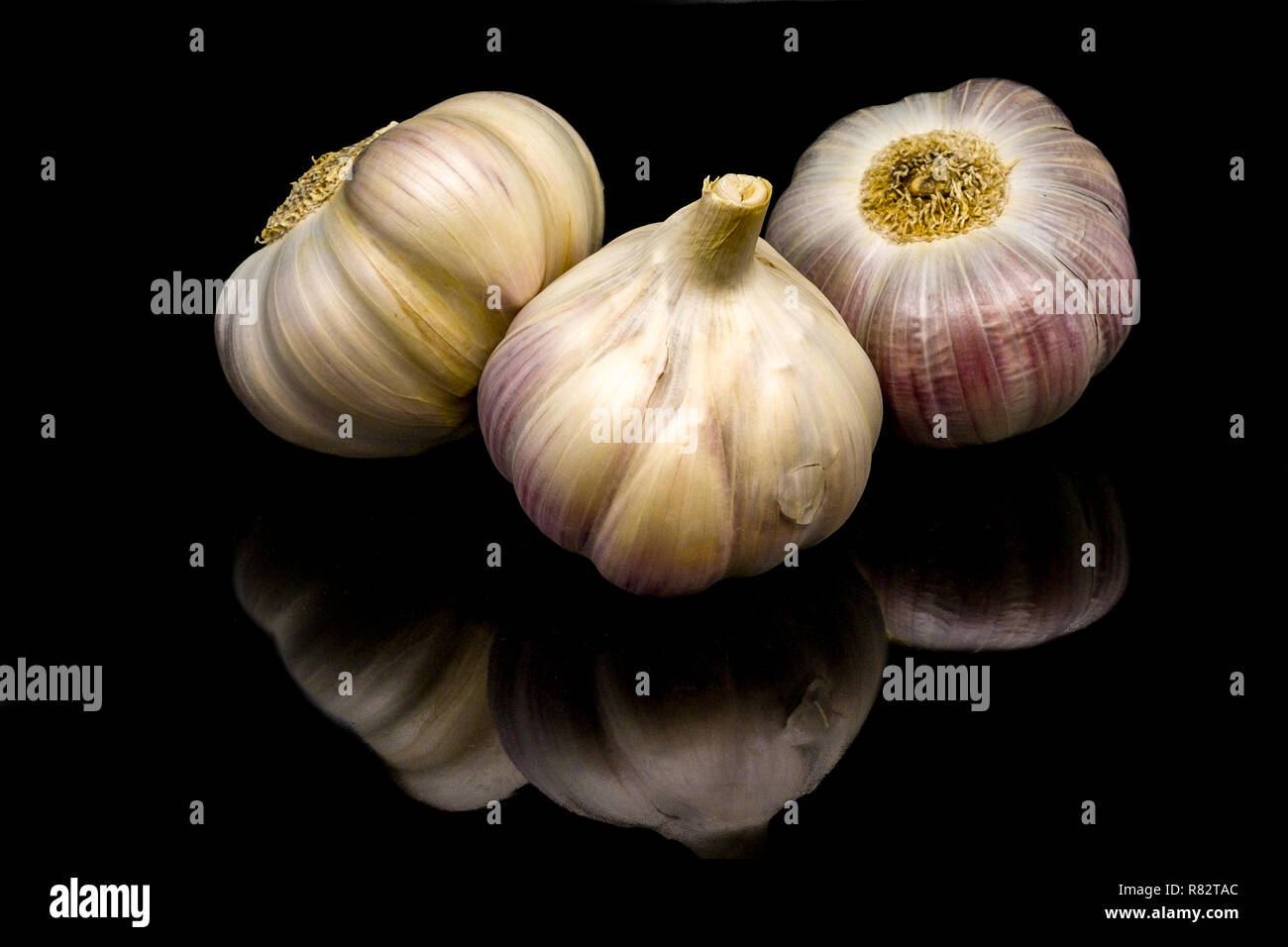 Three garlic bulbs on black background Stock Photo