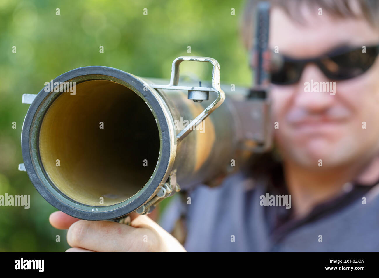 Mercenary in black glasses with anti-tank rocket launcher, RPG in hand. Close-up Stock Photo