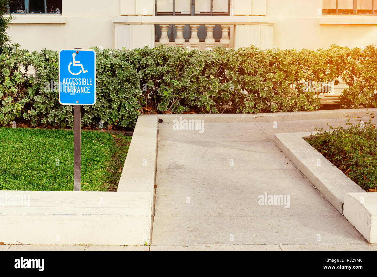 View of a disabled person walk way with a blue handicap sign Stock Photo