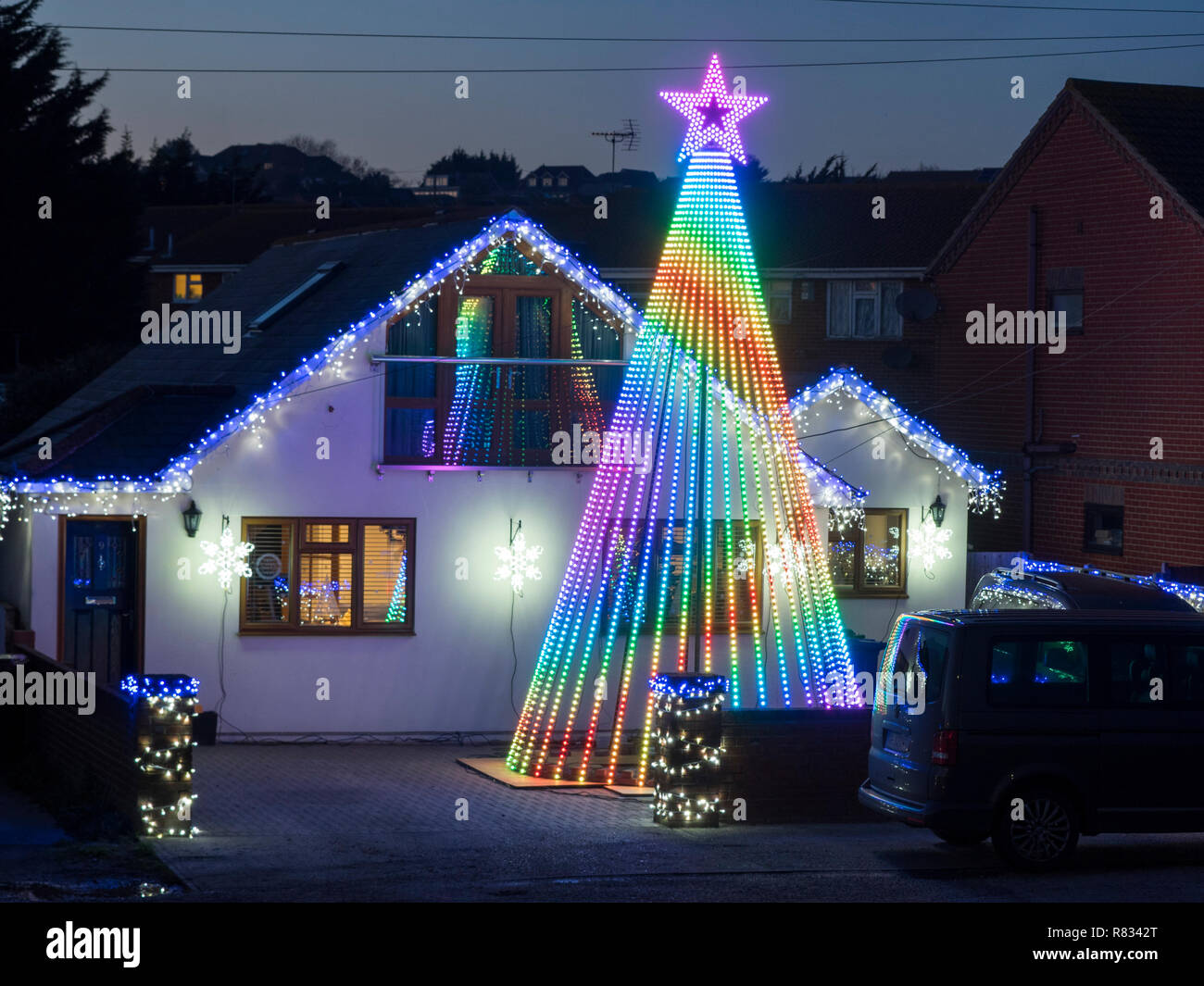 Warden Bay, Kent, UK. 12th December, 2018. A house in Warden Bay, Kent features an impressive Christmas lighting display featuring a huge Christmas Tree (taller than the property) and covered in computer controlled lights that run through various patterns. The display is well known locally as the Jetty Road Christmas Lights. Credit: James Bell/Alamy Live News Stock Photo