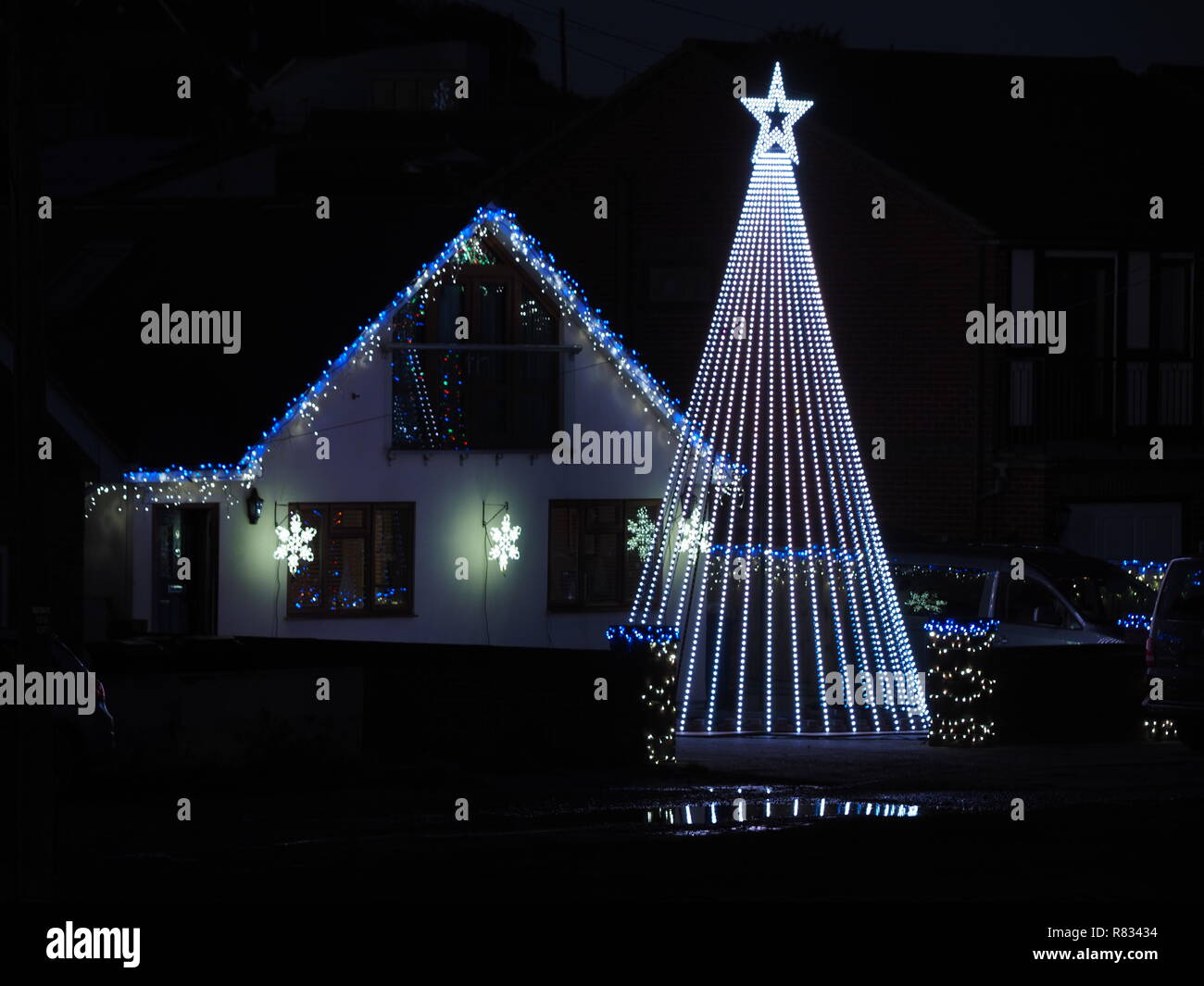 Warden Bay, Kent, UK. 12th December, 2018. A house in Warden Bay, Kent features an impressive Christmas lighting display featuring a huge Christmas Tree (taller than the property) and covered in computer controlled lights that run through various patterns. The display is well known locally as the Jetty Road Christmas Lights. Credit: James Bell/Alamy Live News Stock Photo