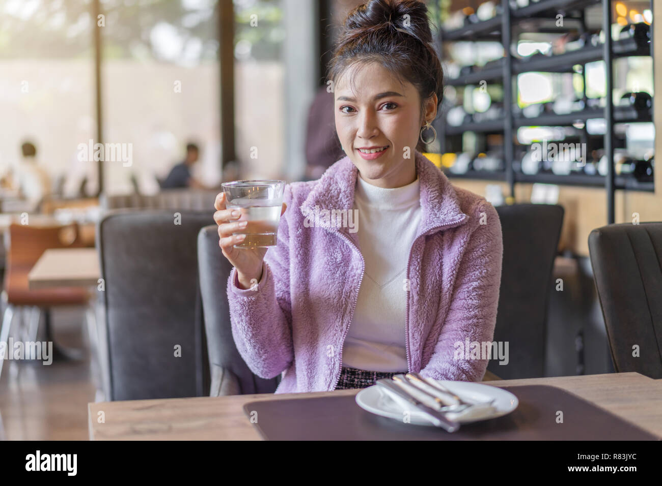 beautiful woman drinking a glass of water in restaurant Stock Photo