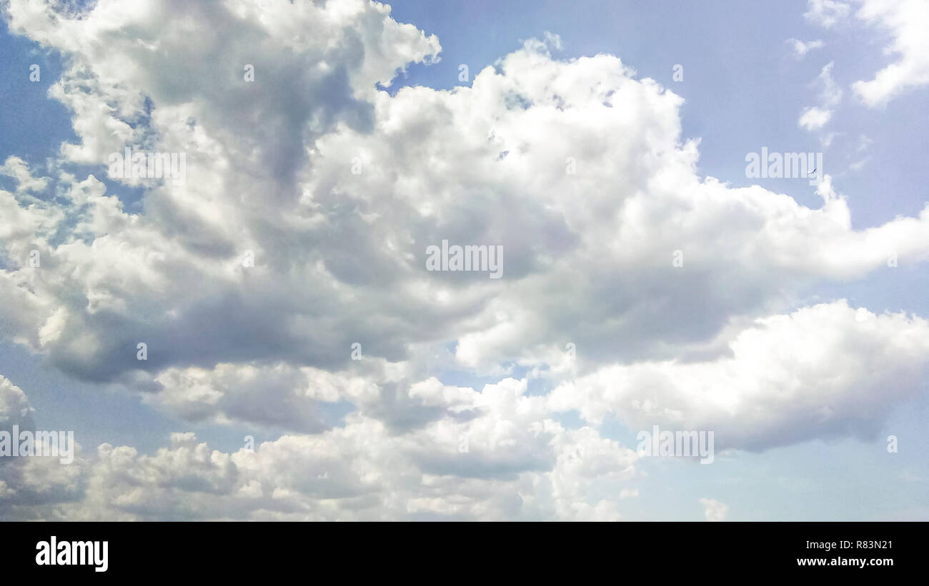 cumulus clouds like fluffy, white cotton balls on the blue sky