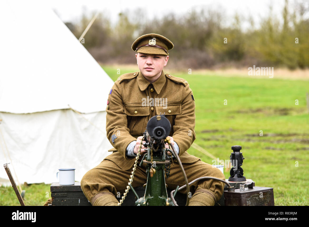 A young male in period First World War, World War One, Great War military uniform. Young soldier with British Army Vickers machine gun. Belt feed Stock Photo