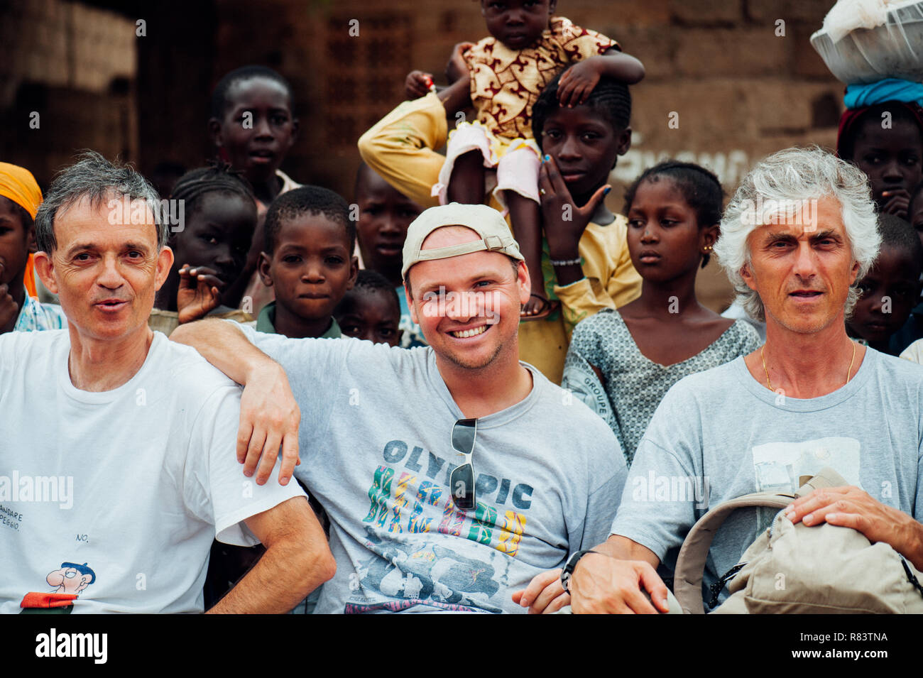 Mali, Africa. White caucasian mature men and black african people enjoying  a children soccer match in a rural village near Bamako Stock Photo - Alamy