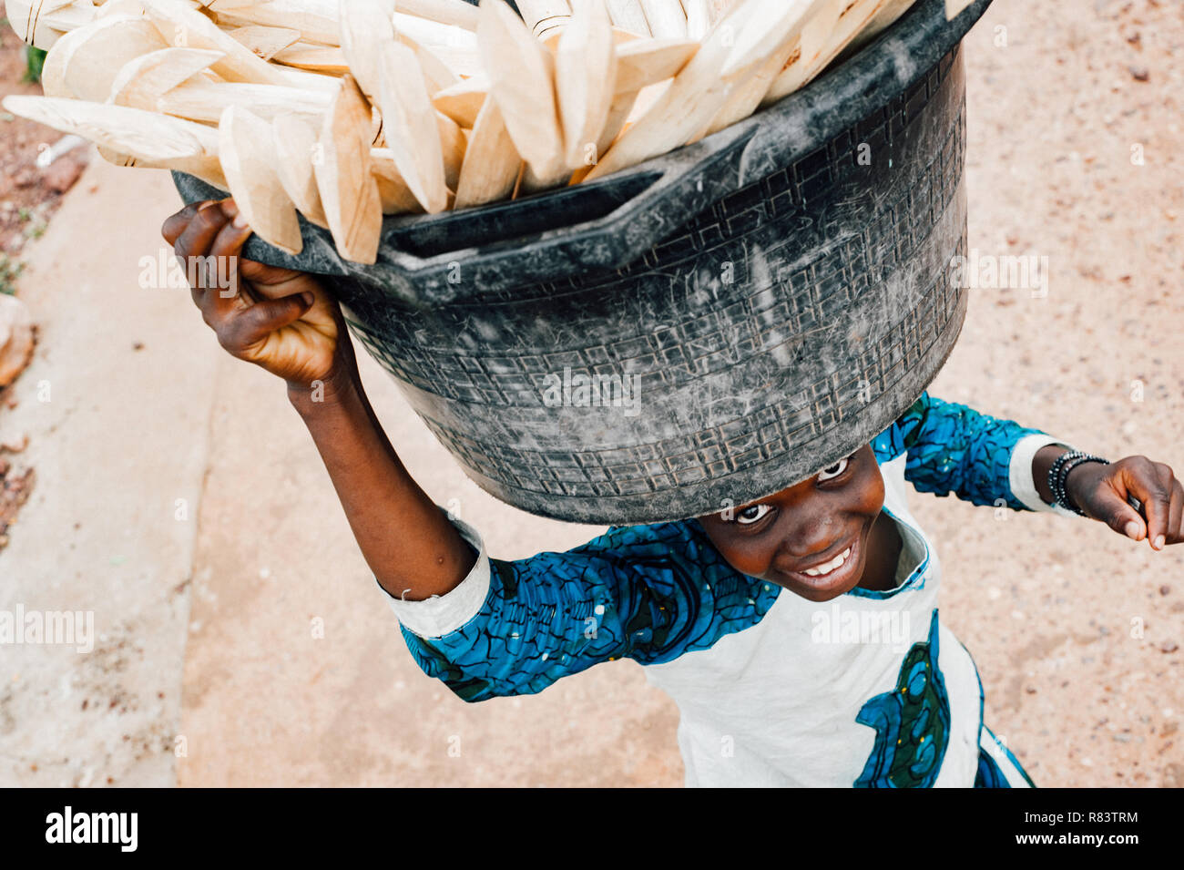 Mali, Africa - Black young boy carrying food on his head. Bamako town urban scene Stock Photo