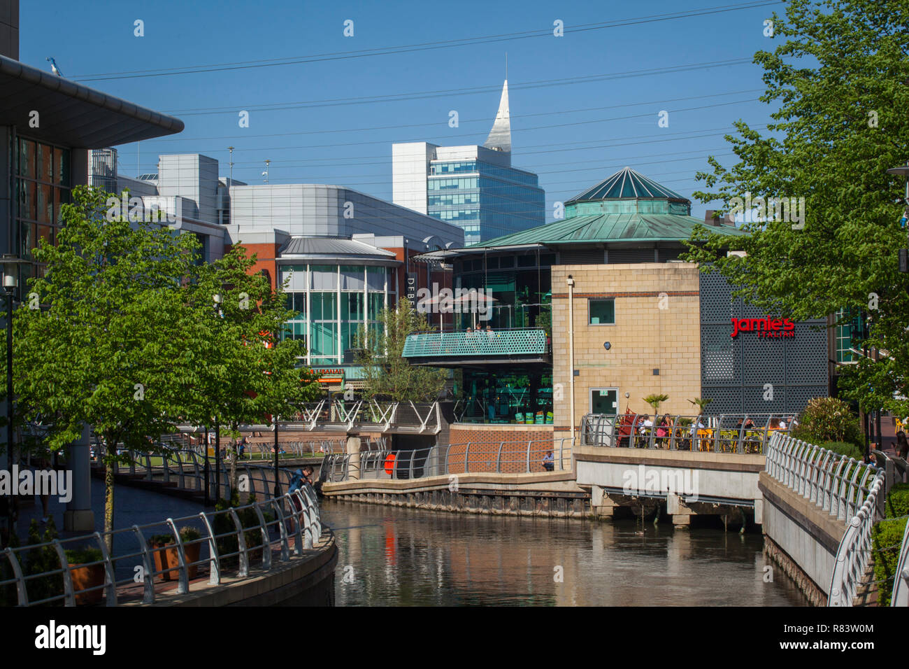The River Kennet flows through the Oracle Shopping Centre in Reading, Berkshire with Debenhams department store at centre left Stock Photo