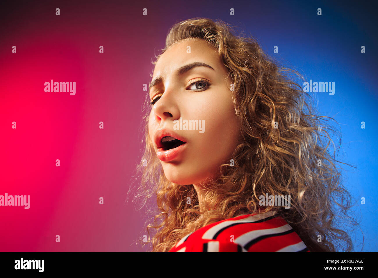 Serious sad woman standing looking at camera isolated on colorful Serious sad woman standing looking at camera isolated on colorful