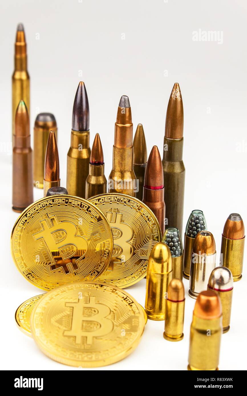 Bitcoin and cartridges of different caliber. Illegal trade in ammunition. Sale of weapons. Financing terrorism. Stock Photo