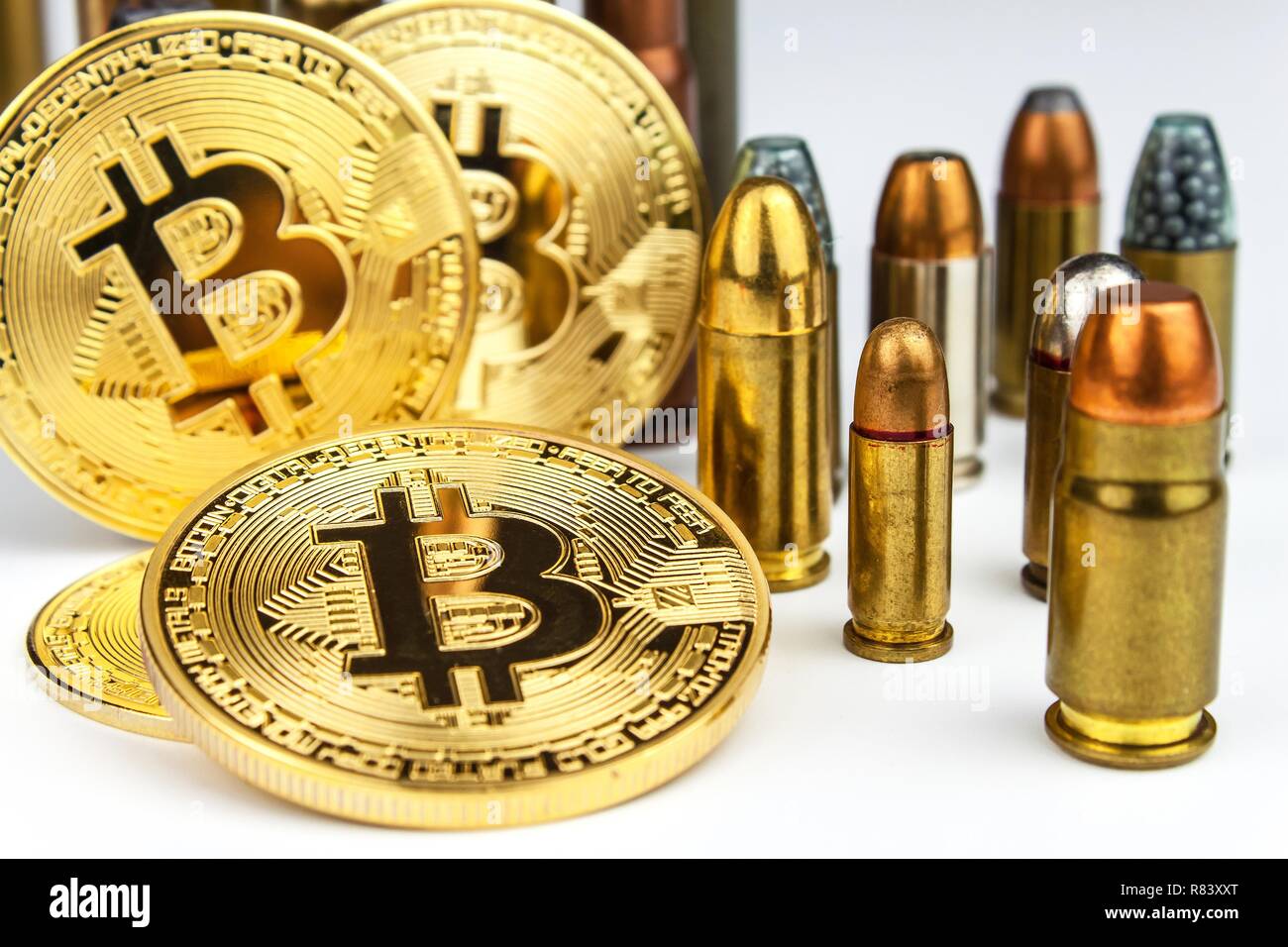 Bitcoin and cartridges of different caliber. Illegal trade in ammunition. Sale of weapons. Financing terrorism. Stock Photo