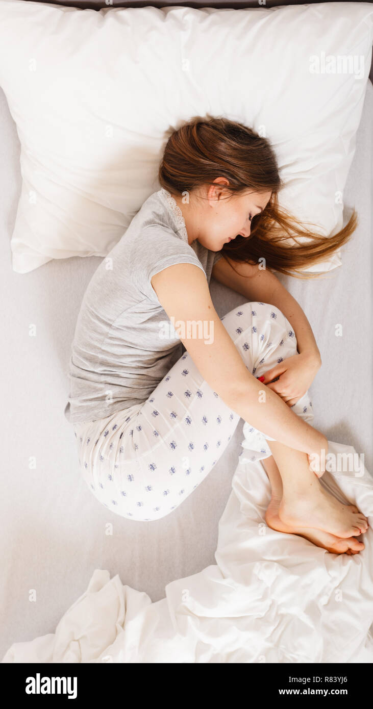 Exhaustion relax dreaming sleep concept. Tired girl sleeping. Young lady  resting in fetal position recovering in bed Stock Photo - Alamy