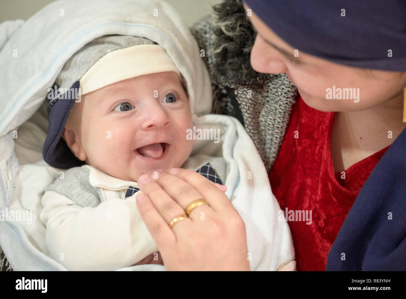 Selvana Mahmad holds her son Ajan Amjad in a clinic in a camp for internally displaced persons at Dawodiya in Iraq's Kurdistan region. Stock Photo