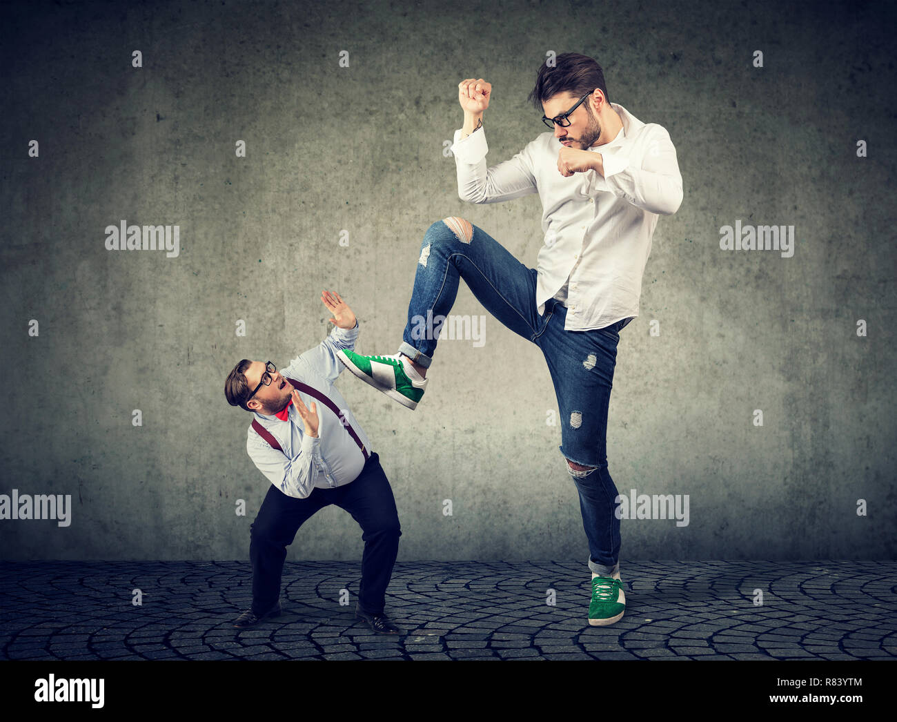 Little business man being crushed by a giant hipster guy Stock Photo