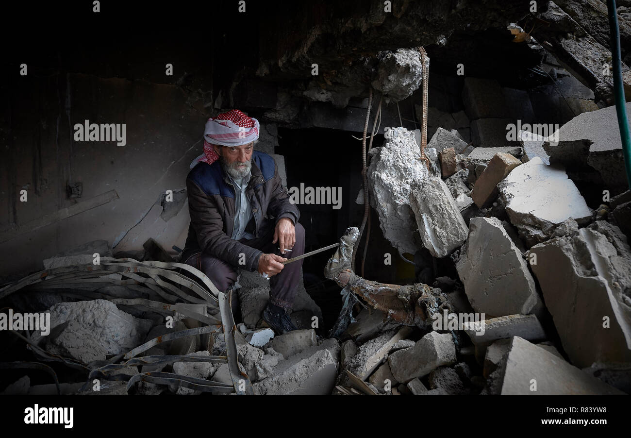 Qasim Yahia Ali, 75, displays the foot and leg of a body trapped in the rubble of his home in the old city of Mosul, Iraq. Stock Photo
