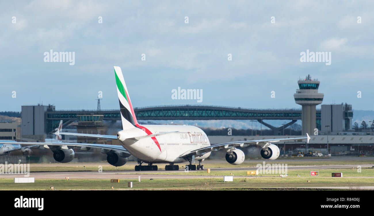 GATWICK AIRPORT, UK – DECEMBER 09 2018: Emirates Airline A380 Airbus taxis after landing at London Gatwick Airport, plus air traffic control tower. Stock Photo