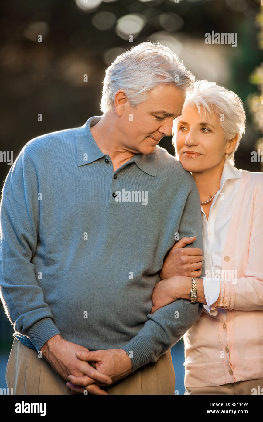 Portrait of a mature couple standing arm in arm. Stock Photo