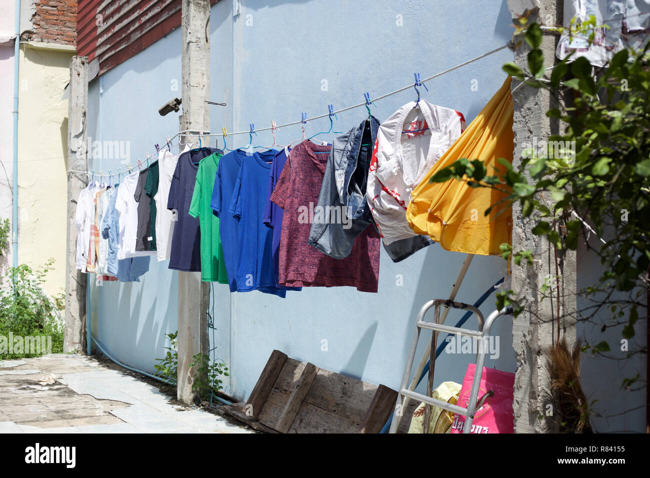 Wet clothes hanging on a line drying under the sun. Stock Photo