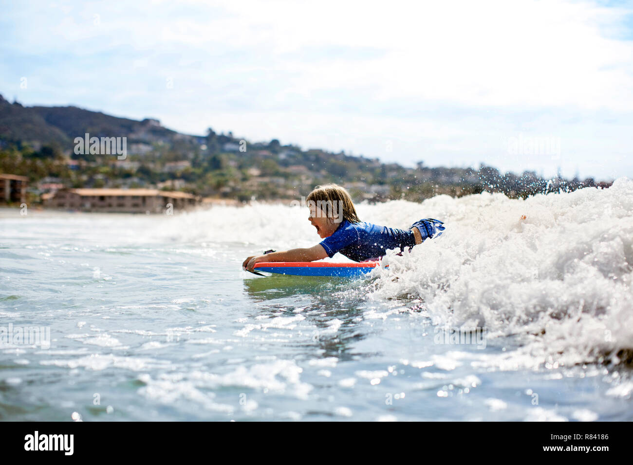 Boy riding a wave on boogie board Stock Photo Alamy