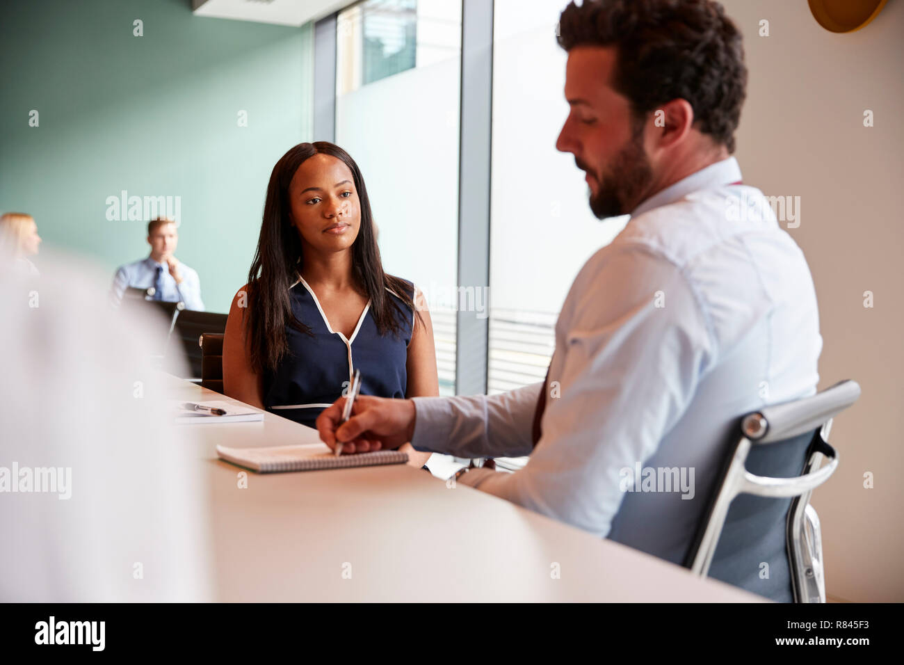 Businesswoman And Businessman Collaborating On Task Together At Graduate Recruitment Assessment Day Stock Photo