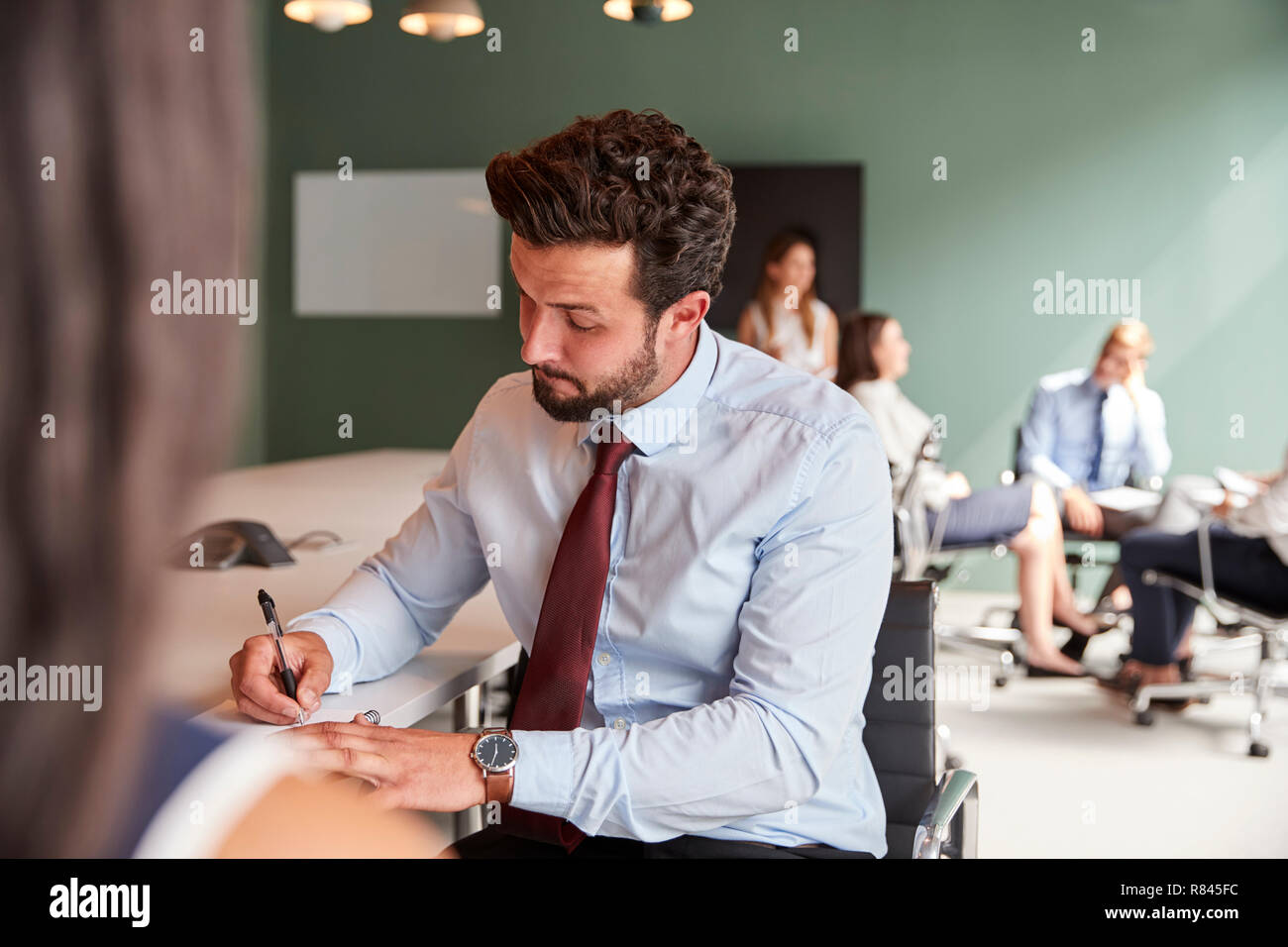 Businesswoman And Businessman Collaborating On Task Together At Graduate Recruitment Assessment Day Stock Photo