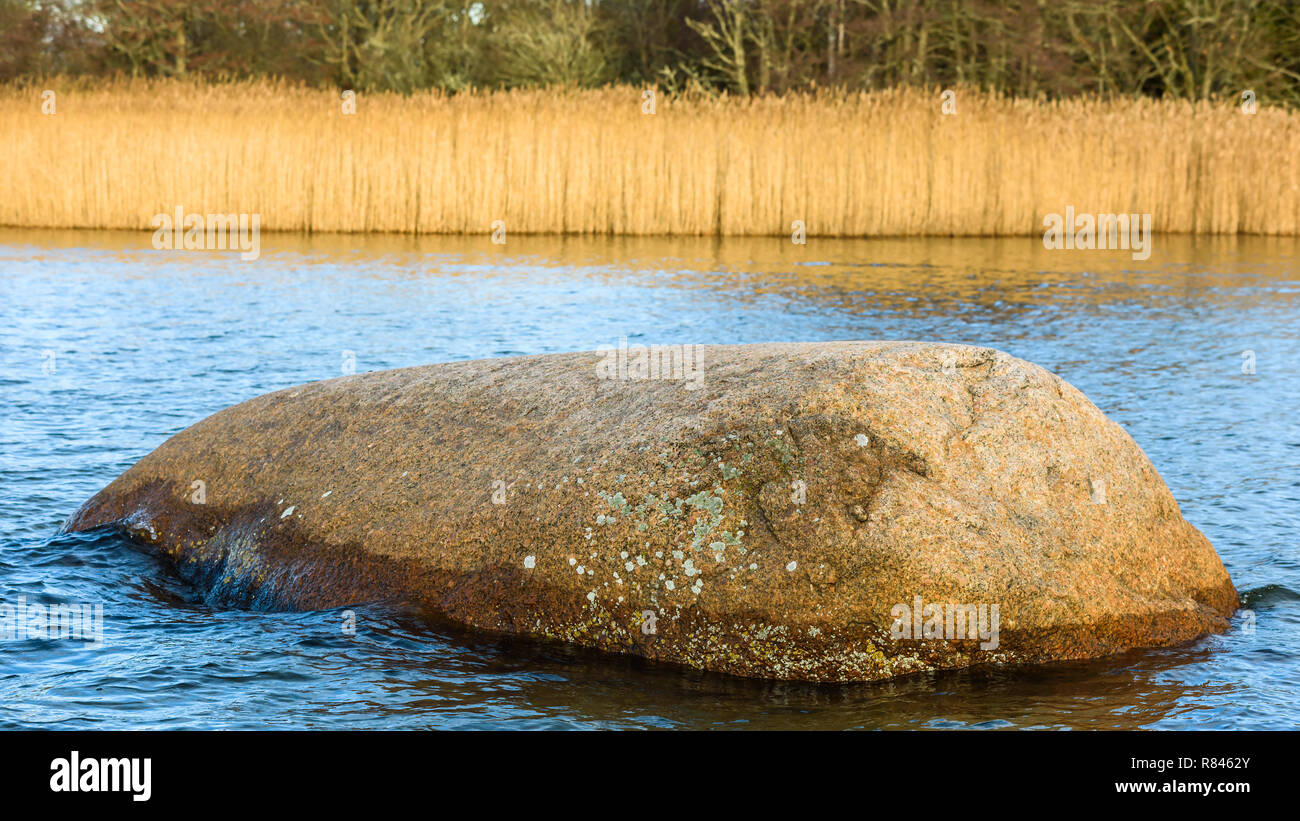 Rock or boulder in coastal waters. Stock Photo