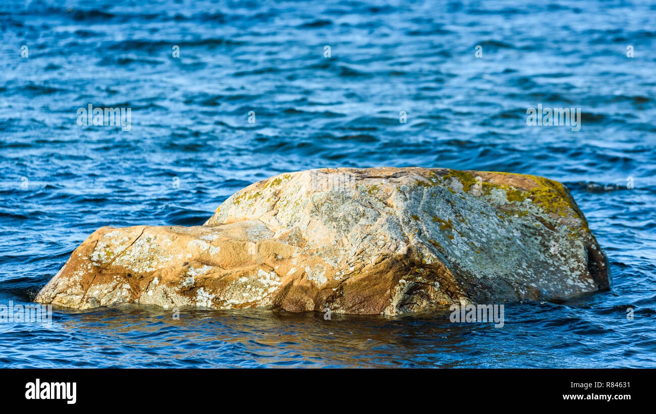 Rock or boulder in coastal waters. Stock Photo