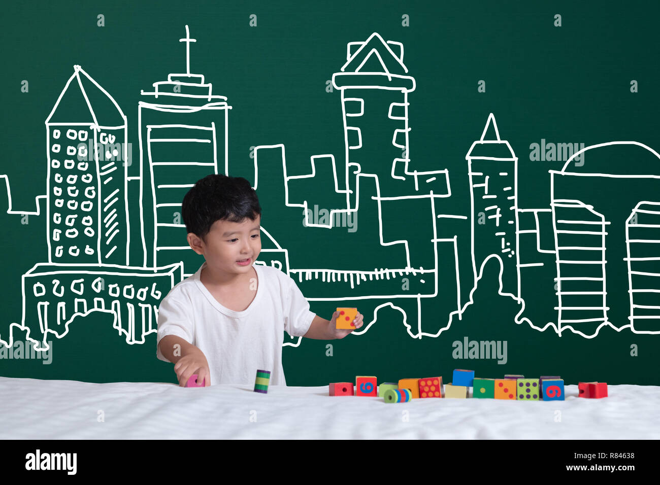 Asian kid learning by playing with his imagination about building and engineer architecture