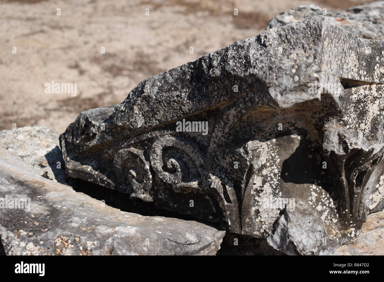 A piece of old archaic sculpture. Ancient carving. Stock Photo