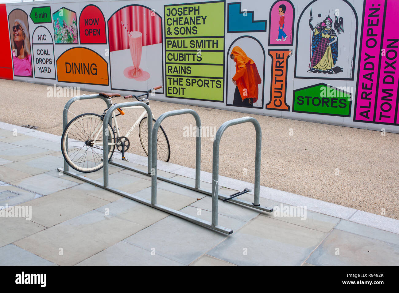 Kings Cross, London, England UK - November 2018: Fixed gear road hipster bike parked in front of billboards promoting the new venue Coal Drops Yard on Stock Photo