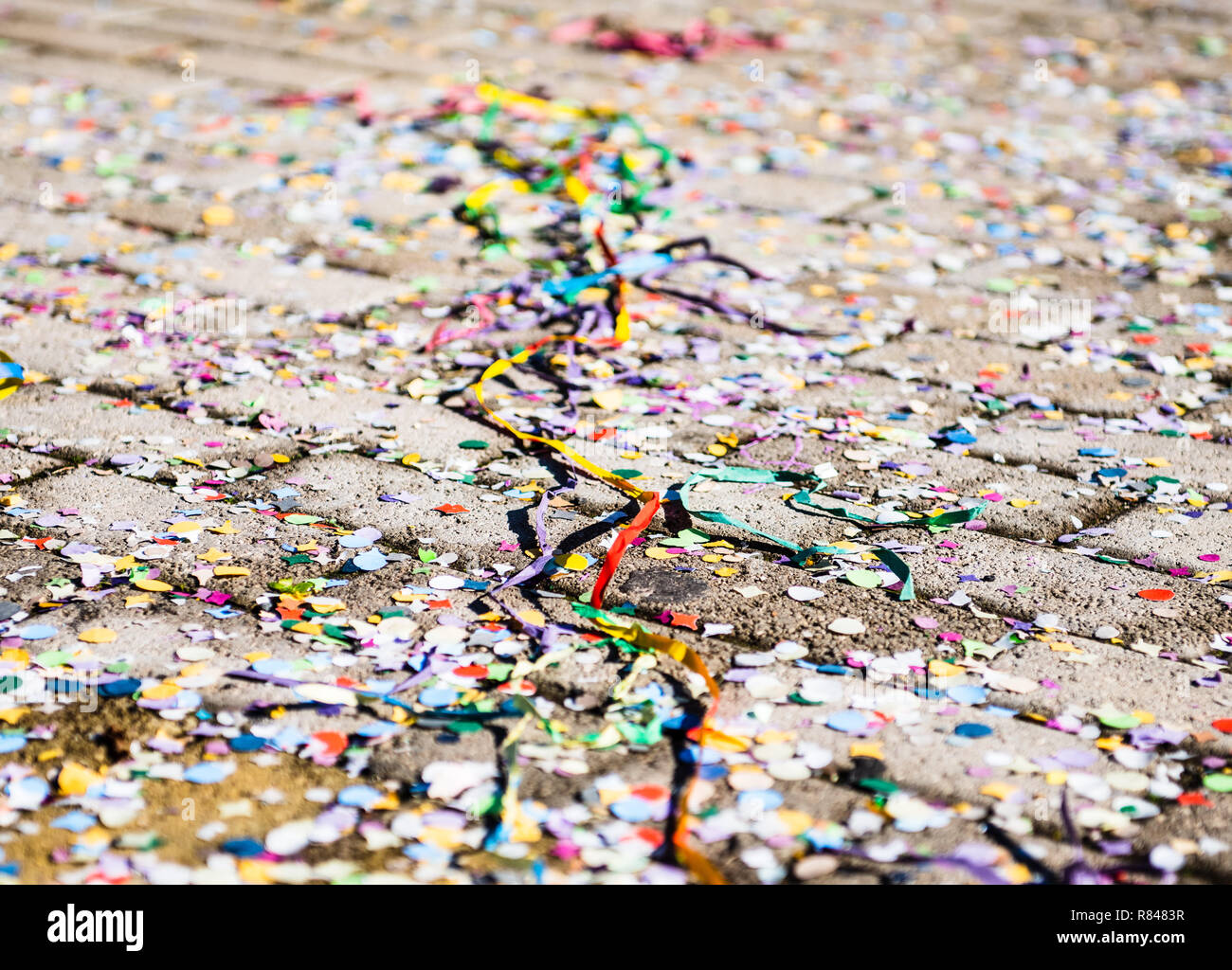 Close up on multicolored streamers wacky strings abandoned on the ground, no people selective focus Stock Photo