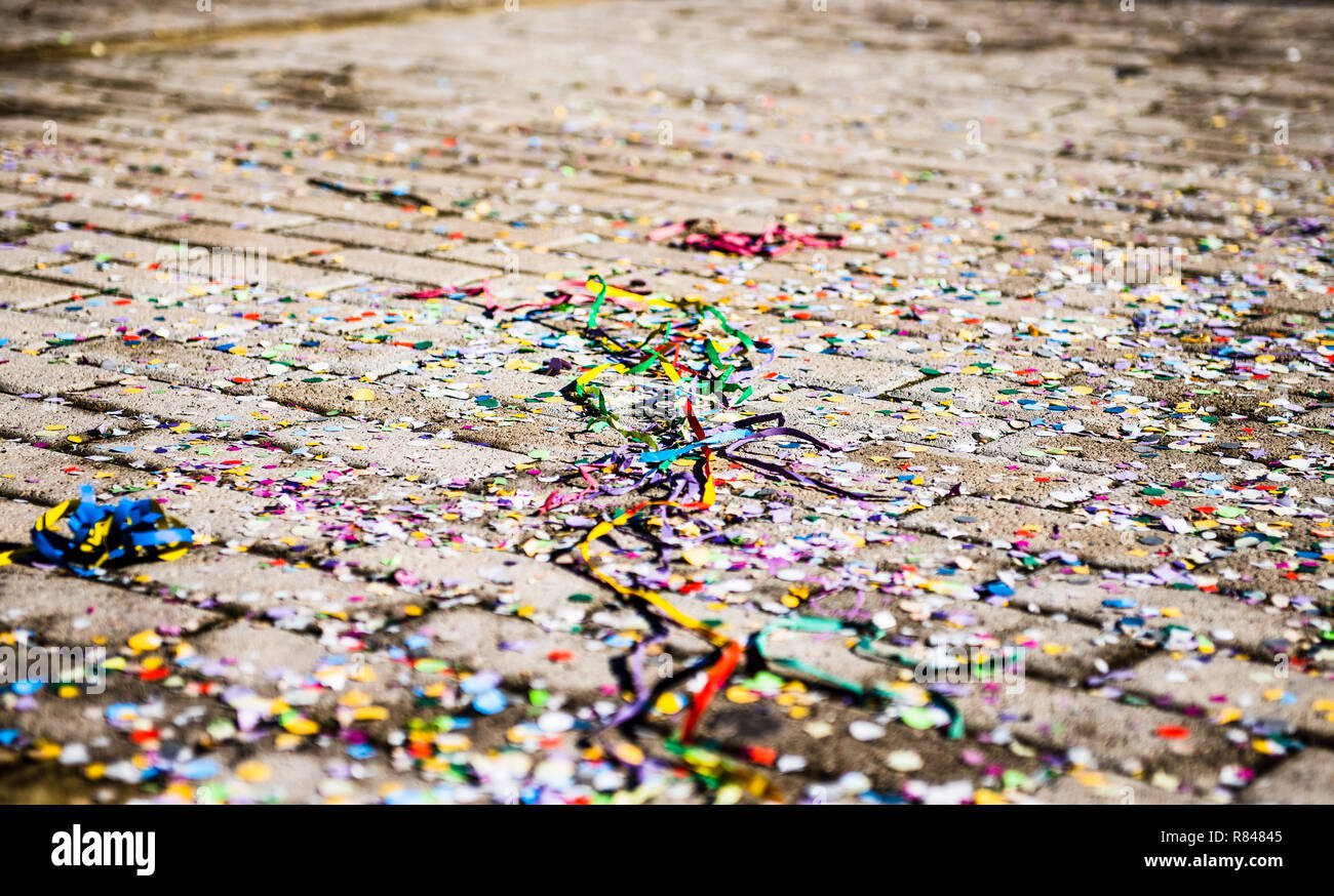 Close up on multicolored streamers wacky strings abandoned on the ground, no people selective focus Stock Photo