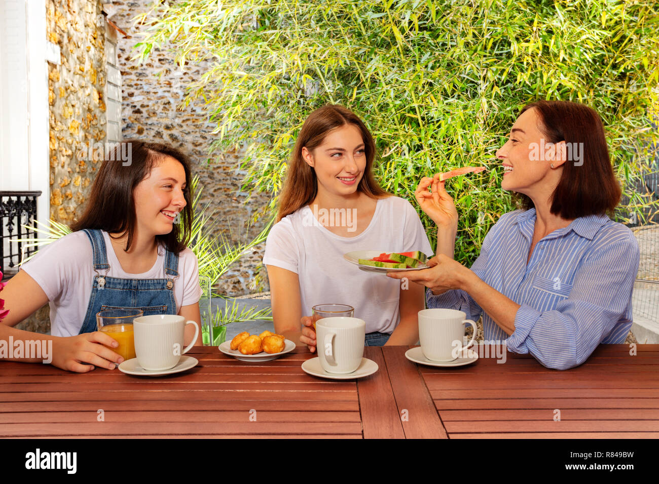 Mother having lunch with two daughters outdoors Stock Photo - Alamy