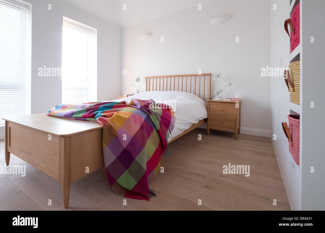 Scandi Style Minimalist Uncluttered Bedroom Interior With Wooden Bedroom Furniture White Painted Walls White Bedding And Colourful Raffia Baskets Stock Photo Alamy