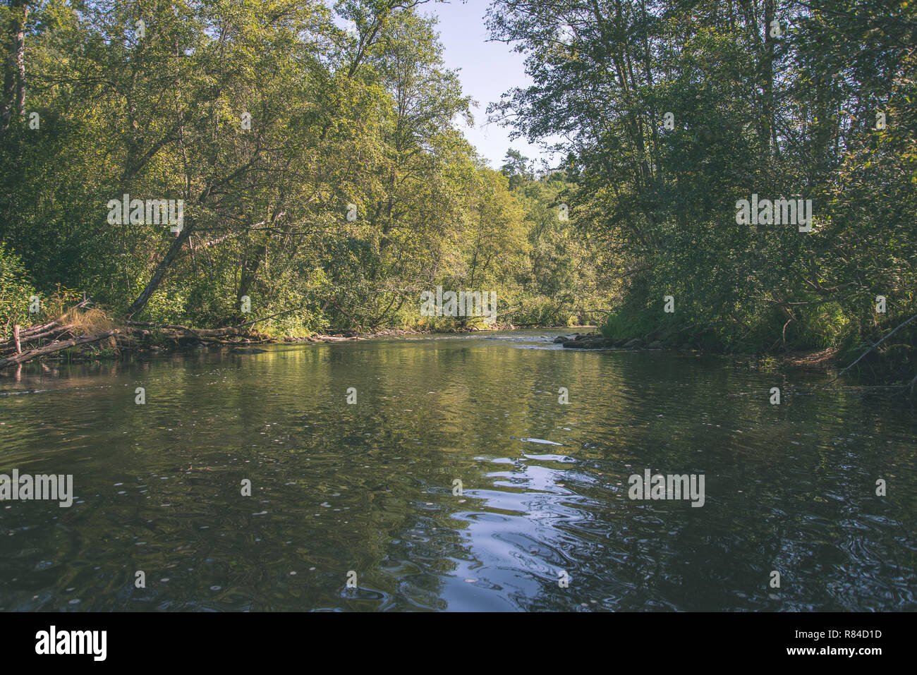 Brasla summer day on water in calm river enclosed in forests with sandstone ...