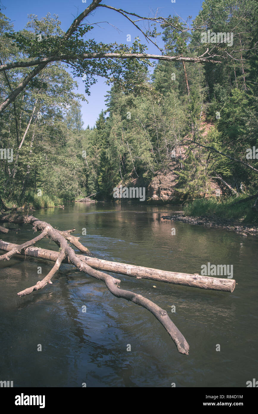 Brasla summer day on water in calm river enclosed in forests with sandstone ...