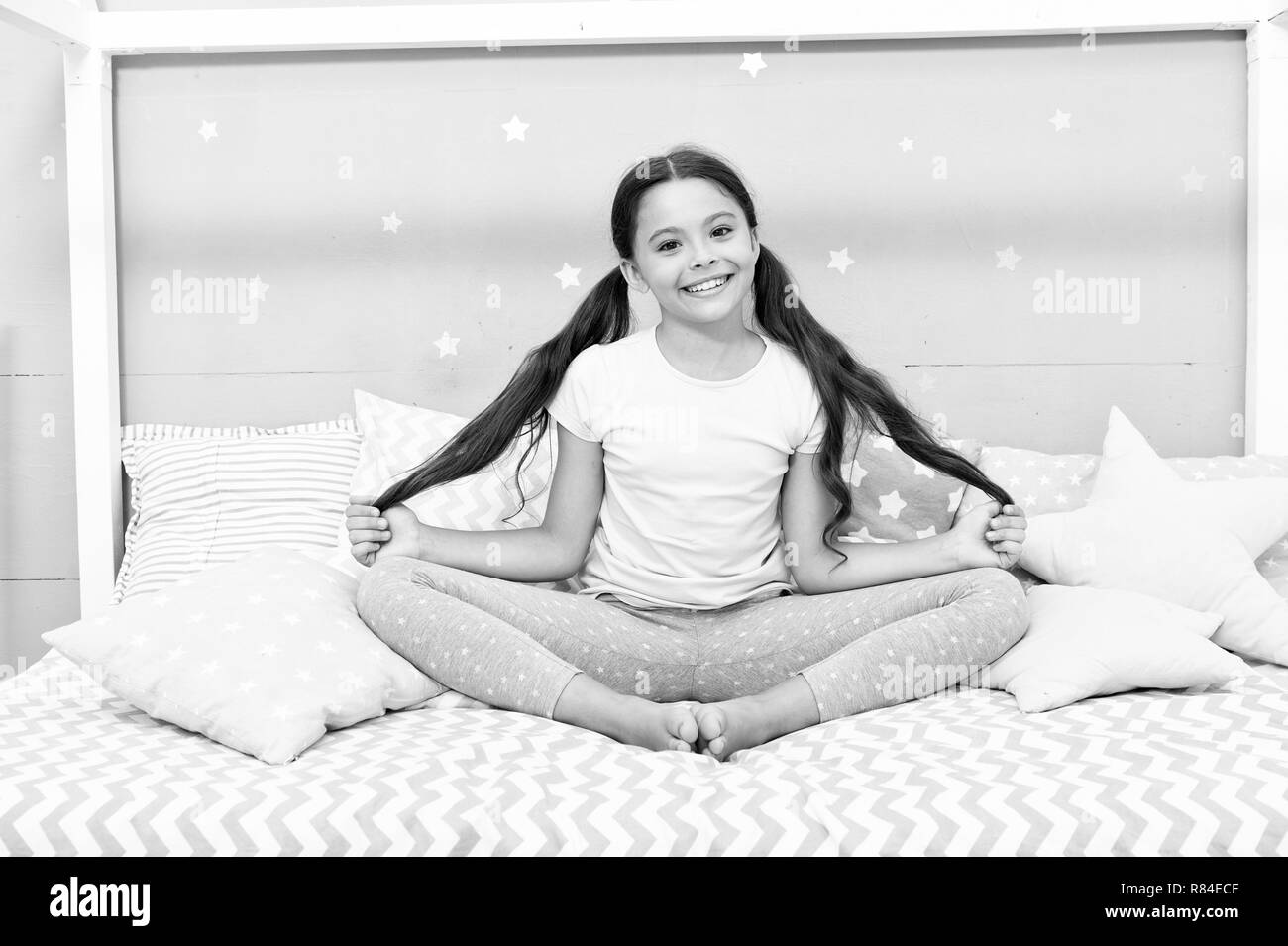 Relaxation and meditation. Girl child sit on bed in her bedroom. Kid ...
