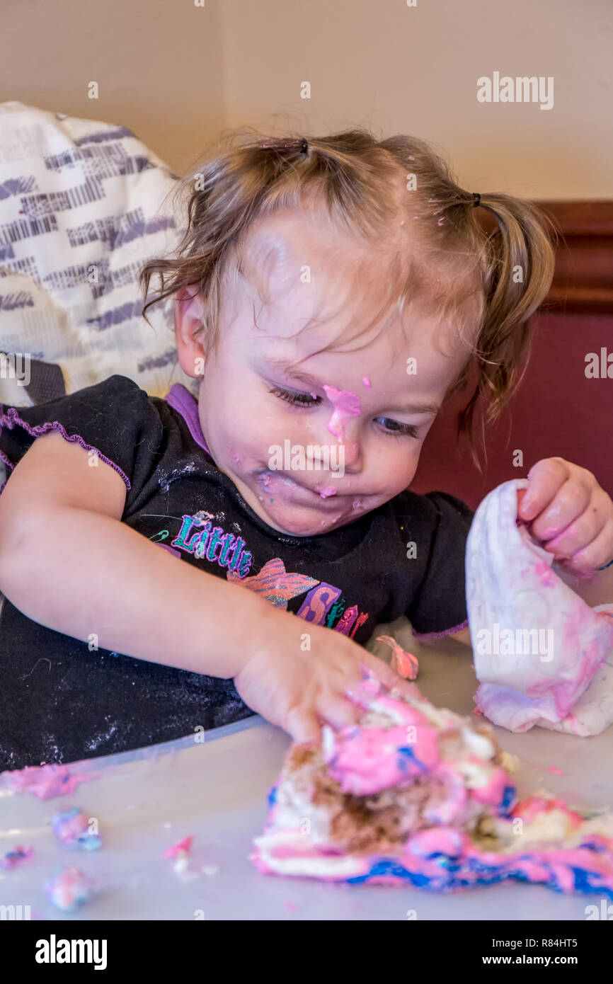 One year old girl discovering how much fun it is to play in one's birthday cake.  (MR) Stock Photo