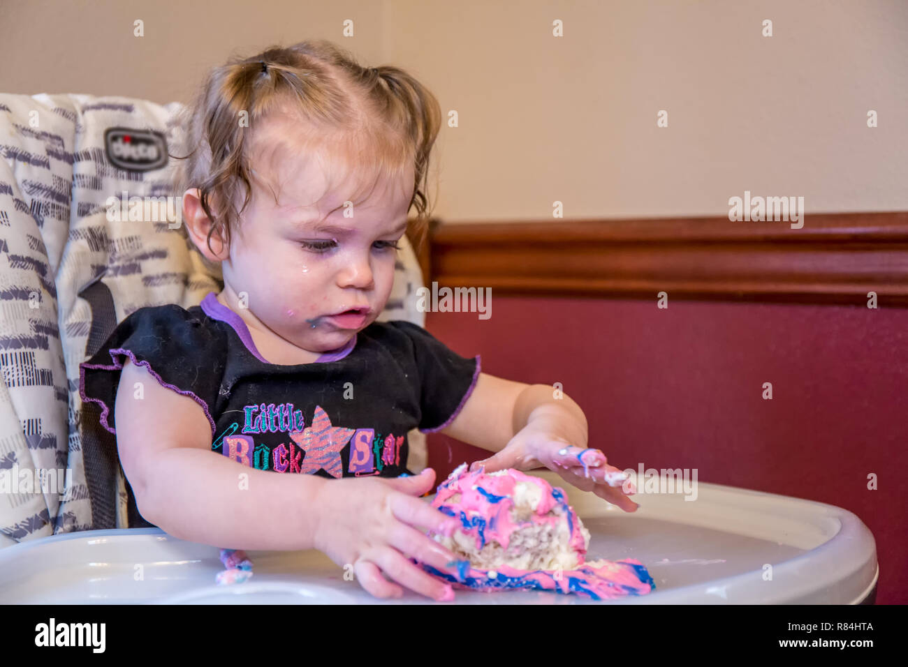 One year old girl discovering how much fun it is to play in one's birthday cake.  (MR) Stock Photo