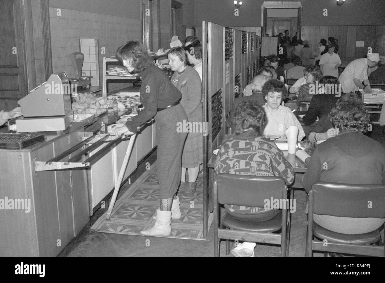 Moscow, USSR - November 23, 1989: Canteen in the Ministry of the Automotive Industry of the USSR. On the left employees standing in line to pay for food. On the right they have dinner or lunch. Stock Photo