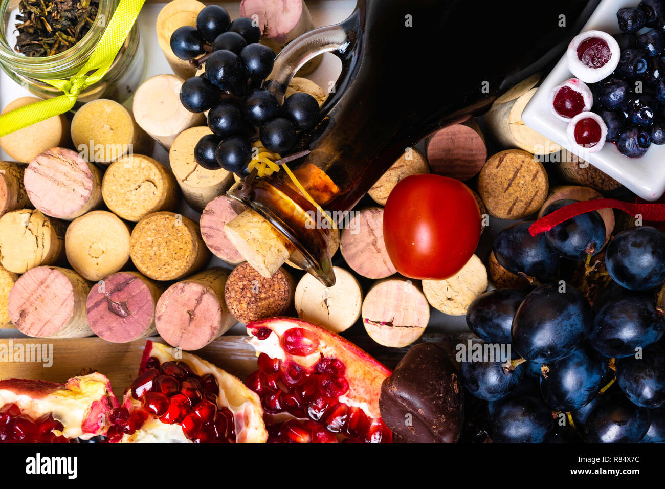 balsamic vinegar in a glass jug with fresh red grapes on wine corks