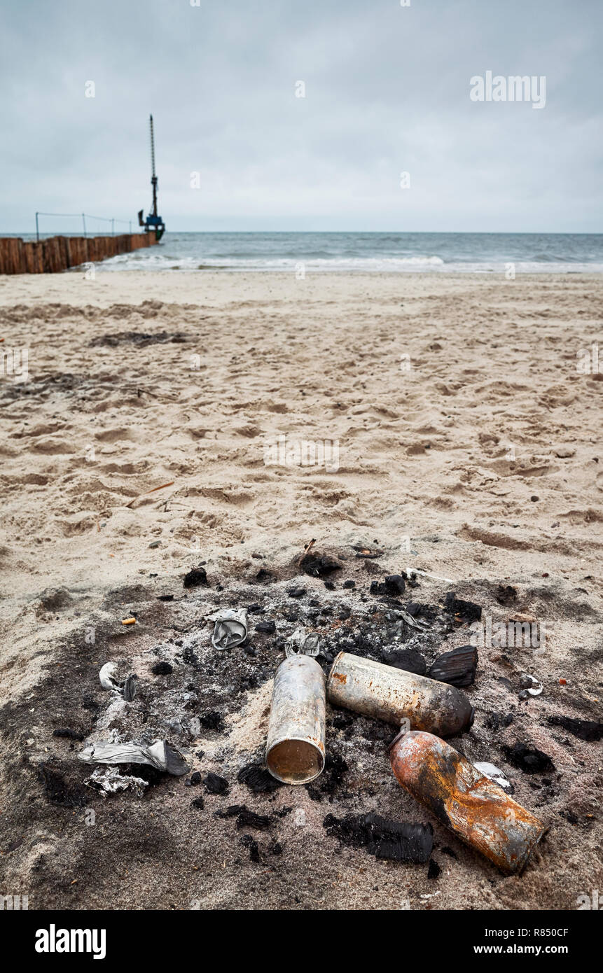 Burnt cans on a beach, environmental pollution concept. Stock Photo