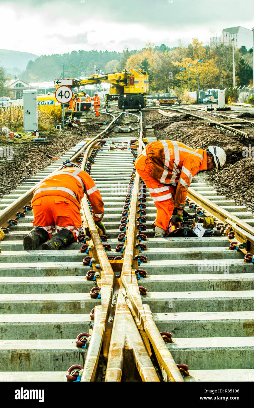 Rail workers laying new track, balls, installing points and laying cables Stock Photo