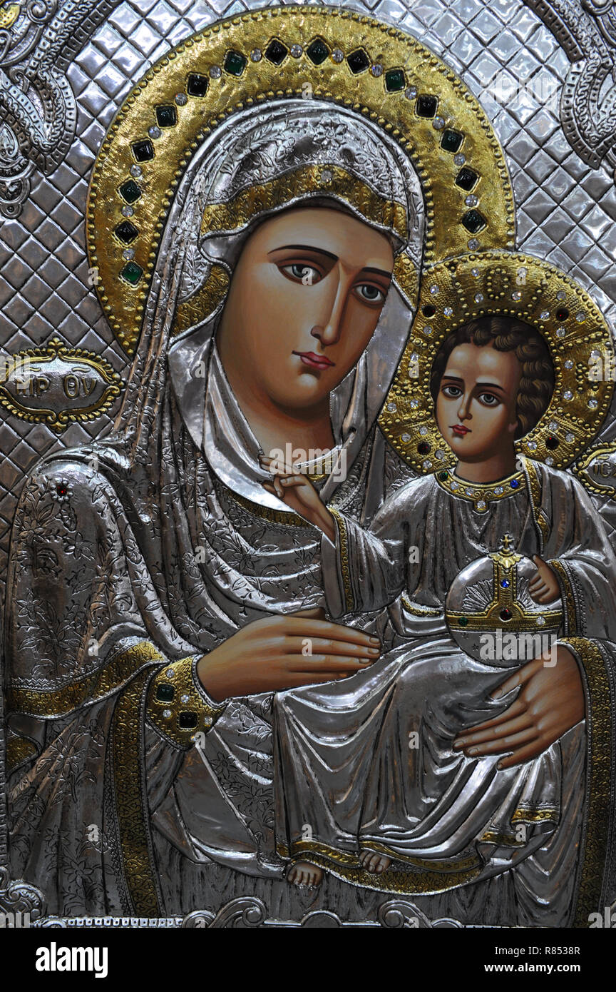 Embossed on metallic plate with silver and gold background outstanding image of Mother Virgin Mary with Baby Jesus Christ. Stock Photo