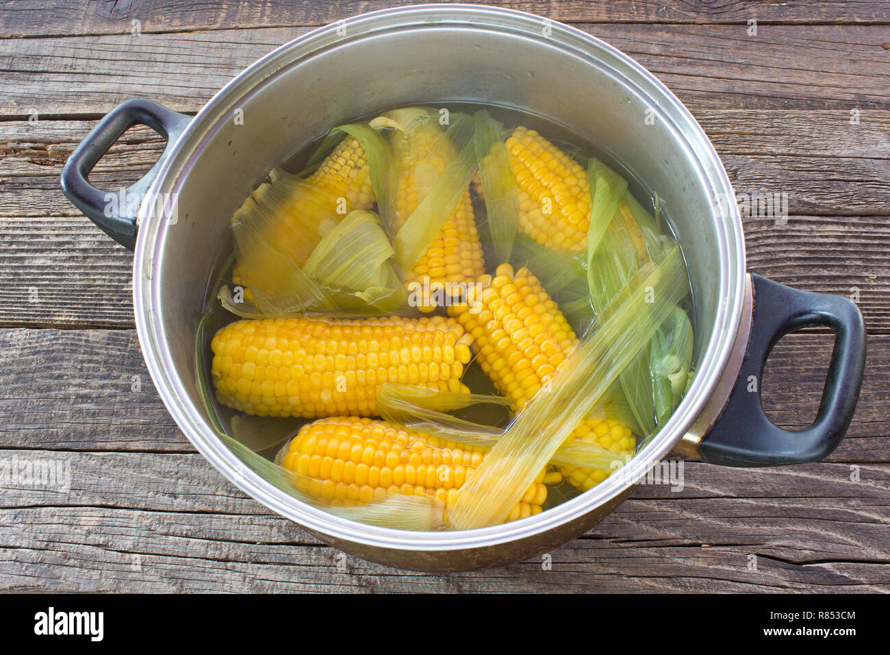 Cooked corn cobs in pot on wooden table Stock Photo - Alamy