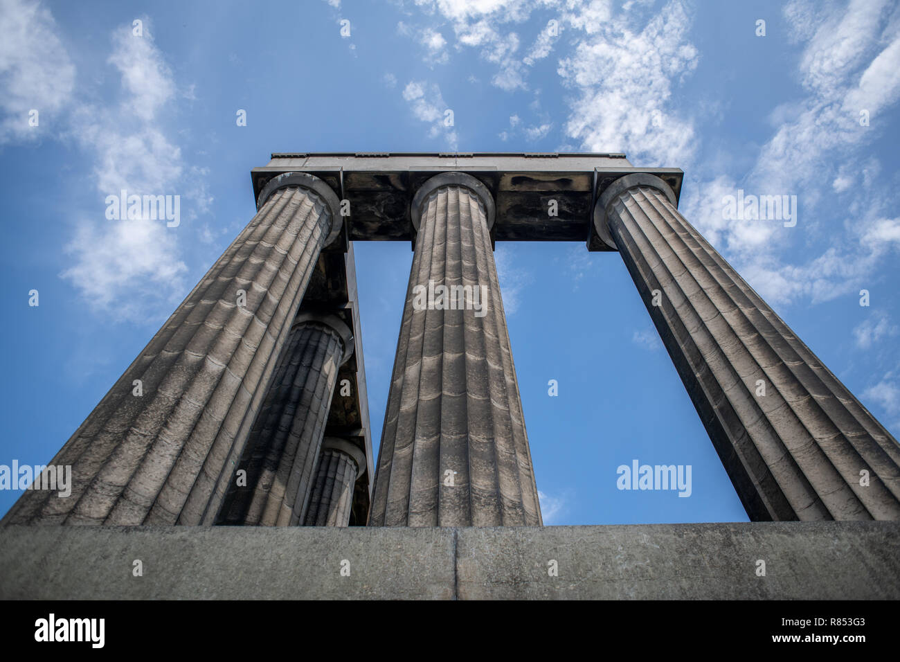 The doric columns of the National Monument of Scotland towers above visitors, Edinburgh, Scotland, UK. Stock Photo